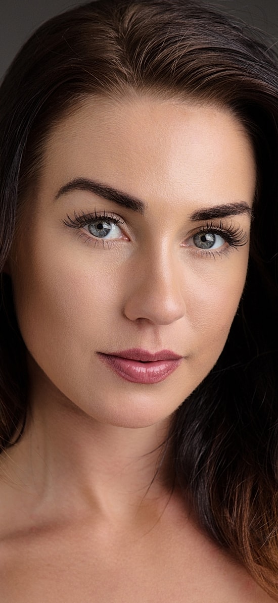 Woman with styled hair and natural makeup.