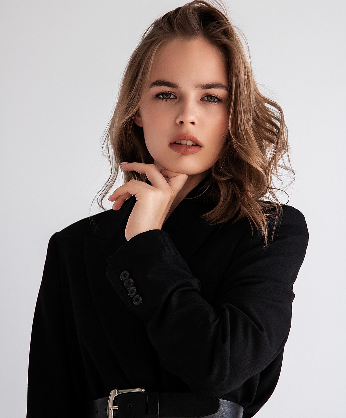 Woman in black blazer posing thoughtfully.