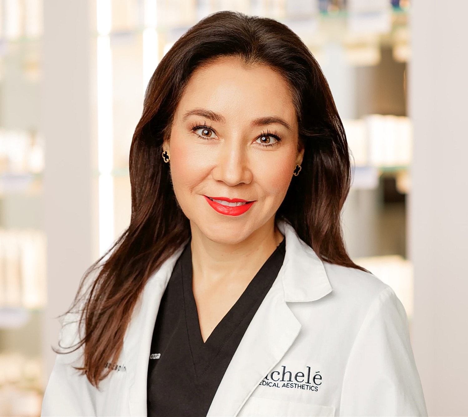 Woman smiling, wearing elegant black attire.