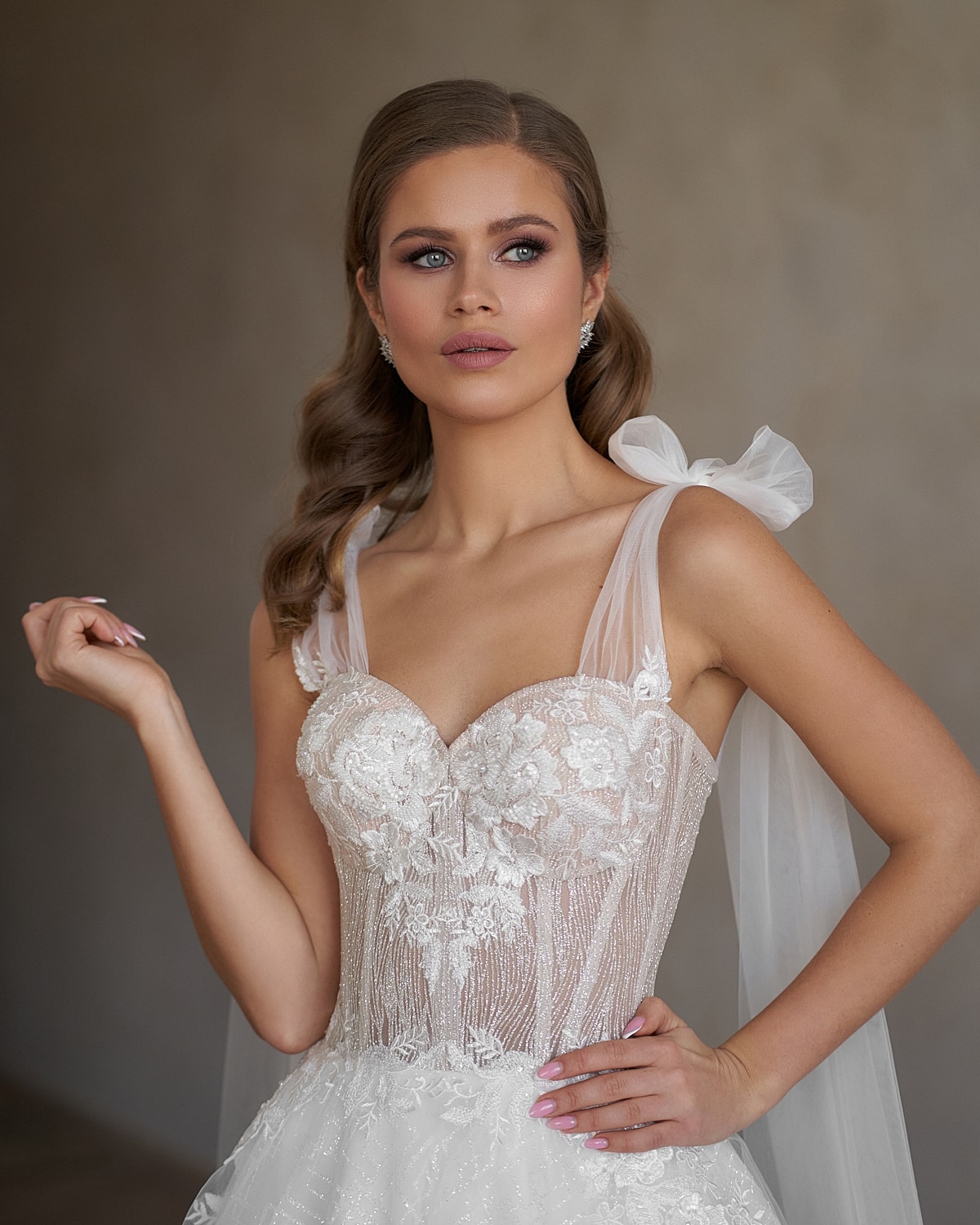 Three women in white lab coats smiling indoors.