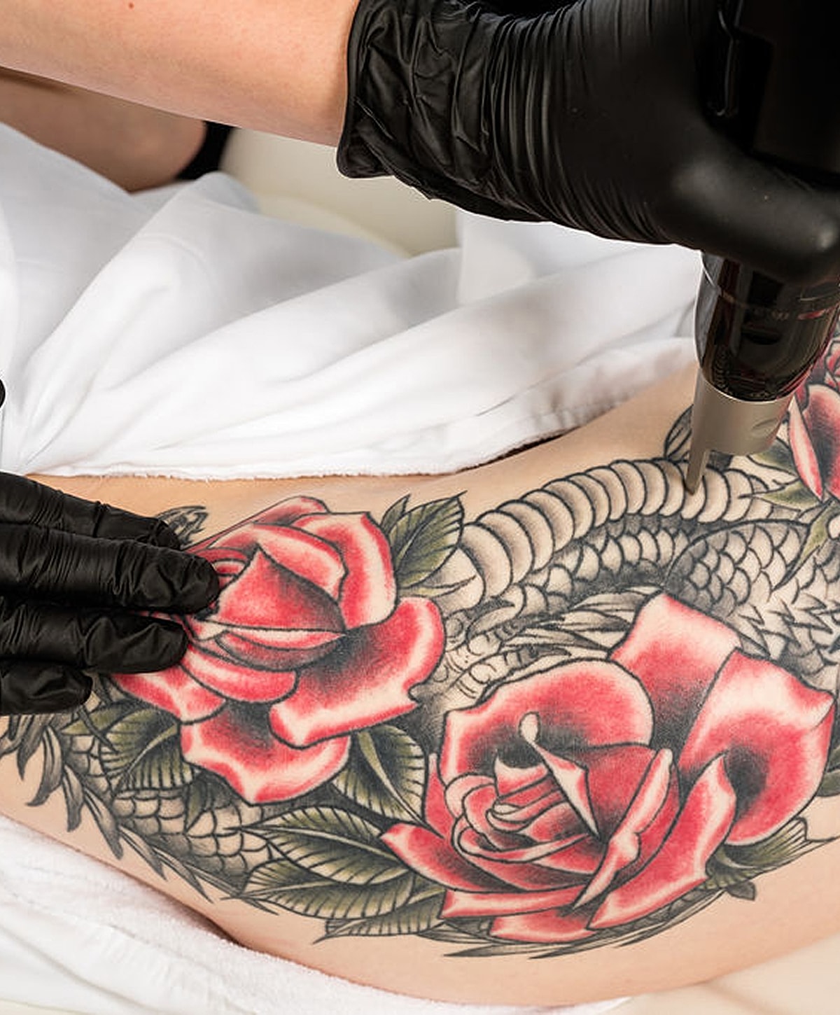 Tattoo artist working on rose tattoo design.