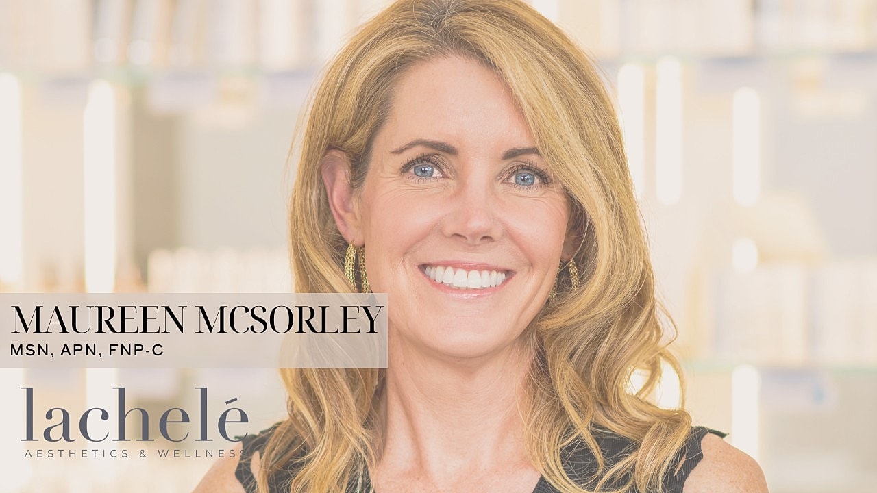 Smiling woman in medical aesthetics setting.