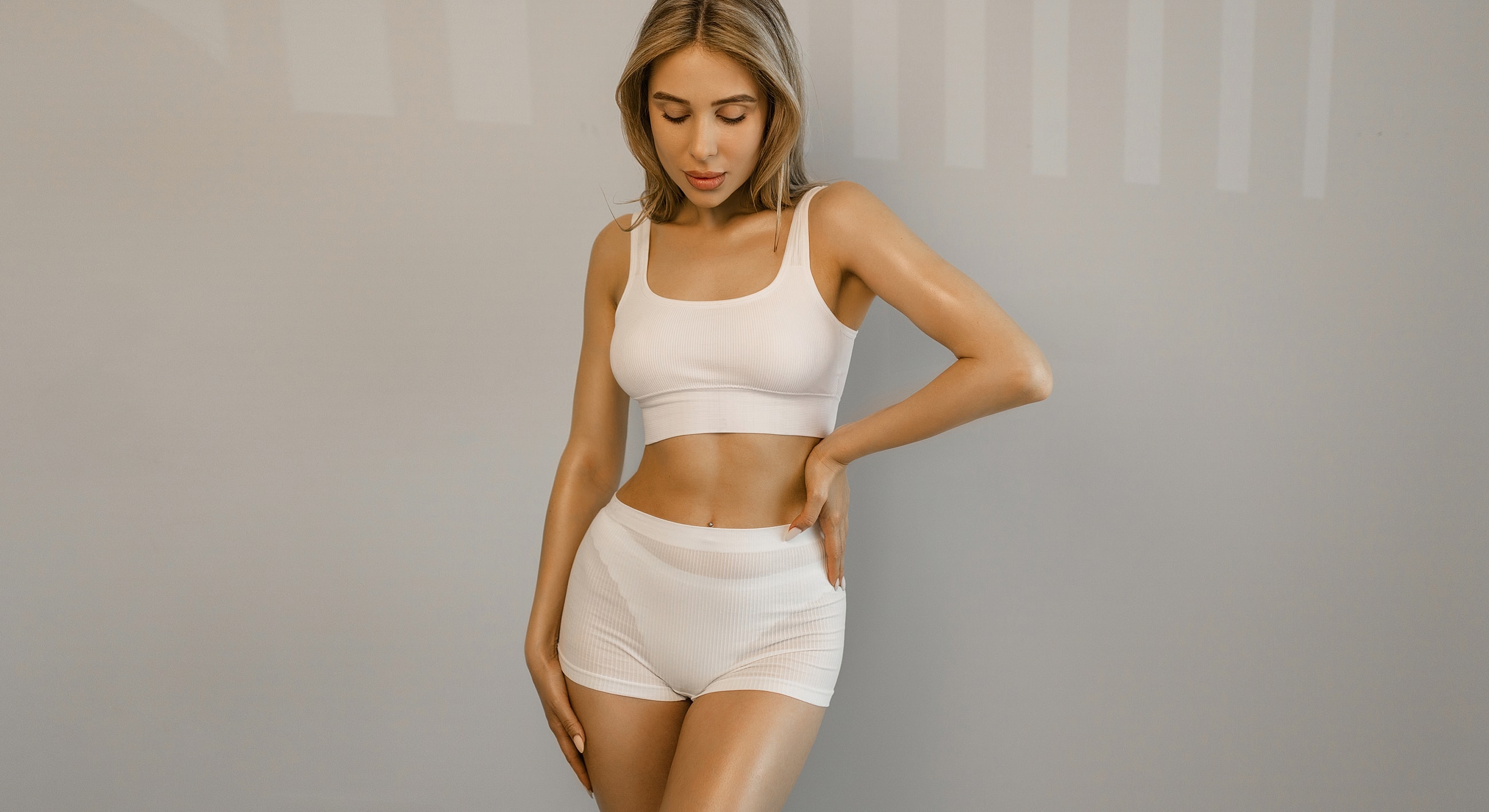 Model in white activewear posing gracefully.