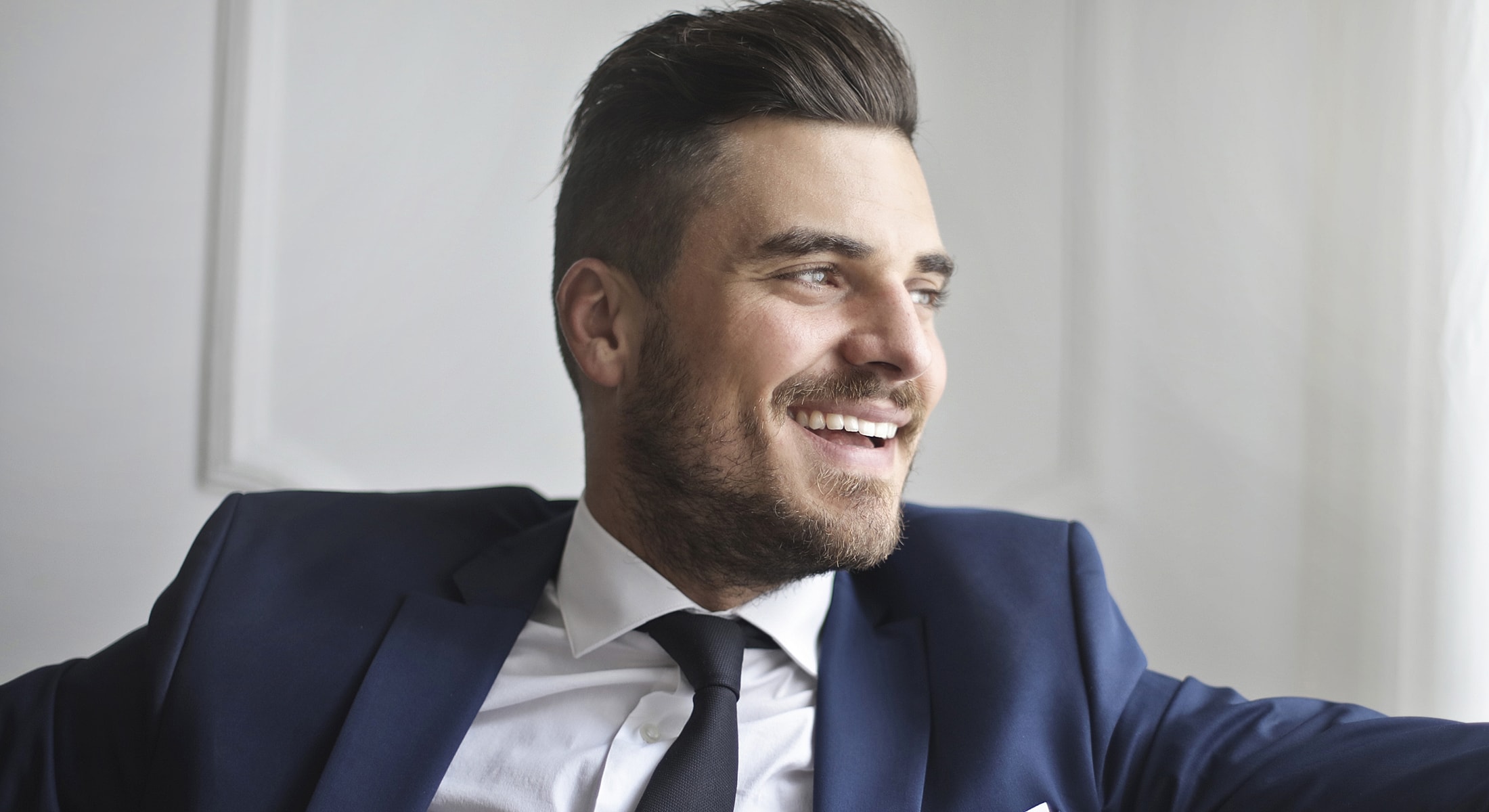 Smiling man in a suit, relaxed and happy.