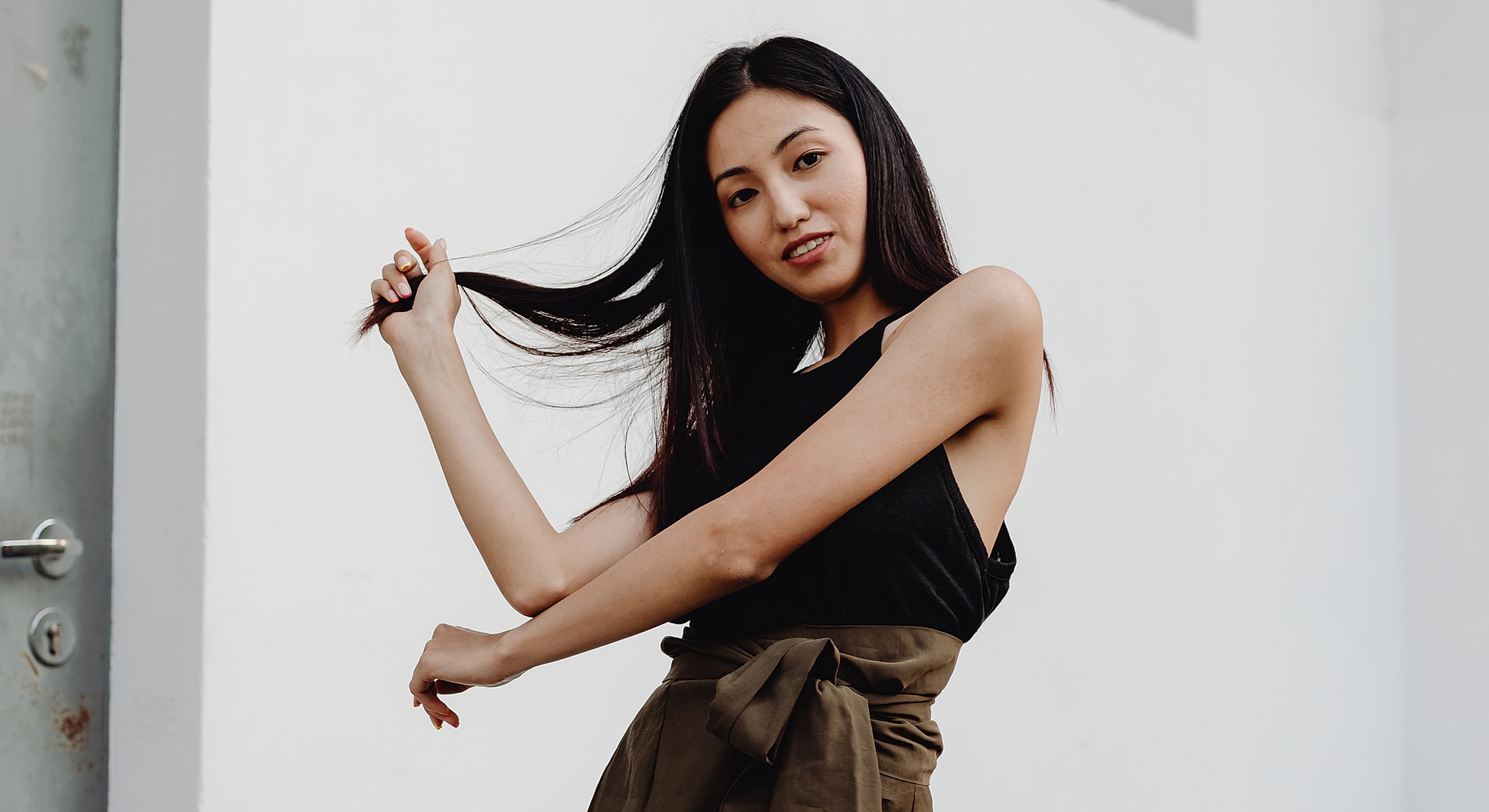 Woman playfully styling her long hair indoors.