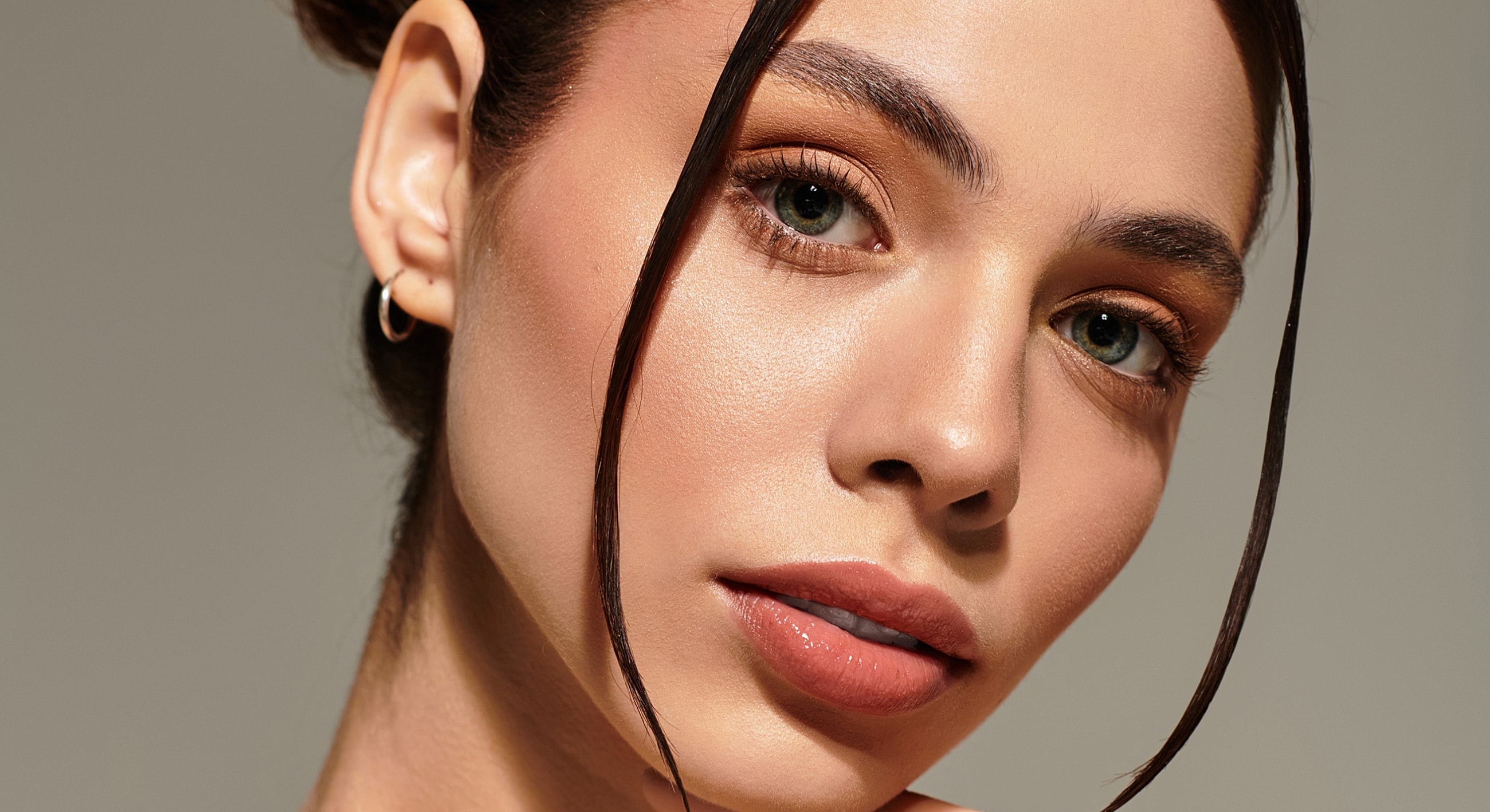 Woman with serious expression touching her face.