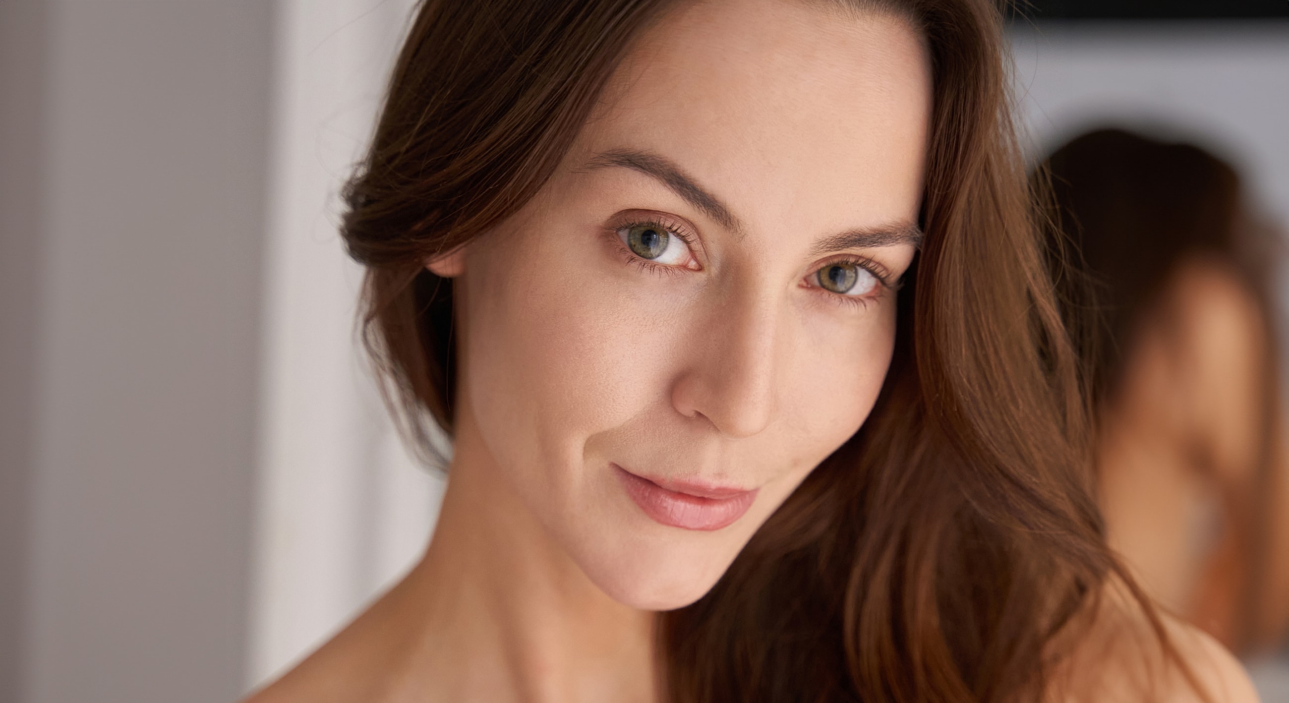 Woman with long hair, smiling softly.