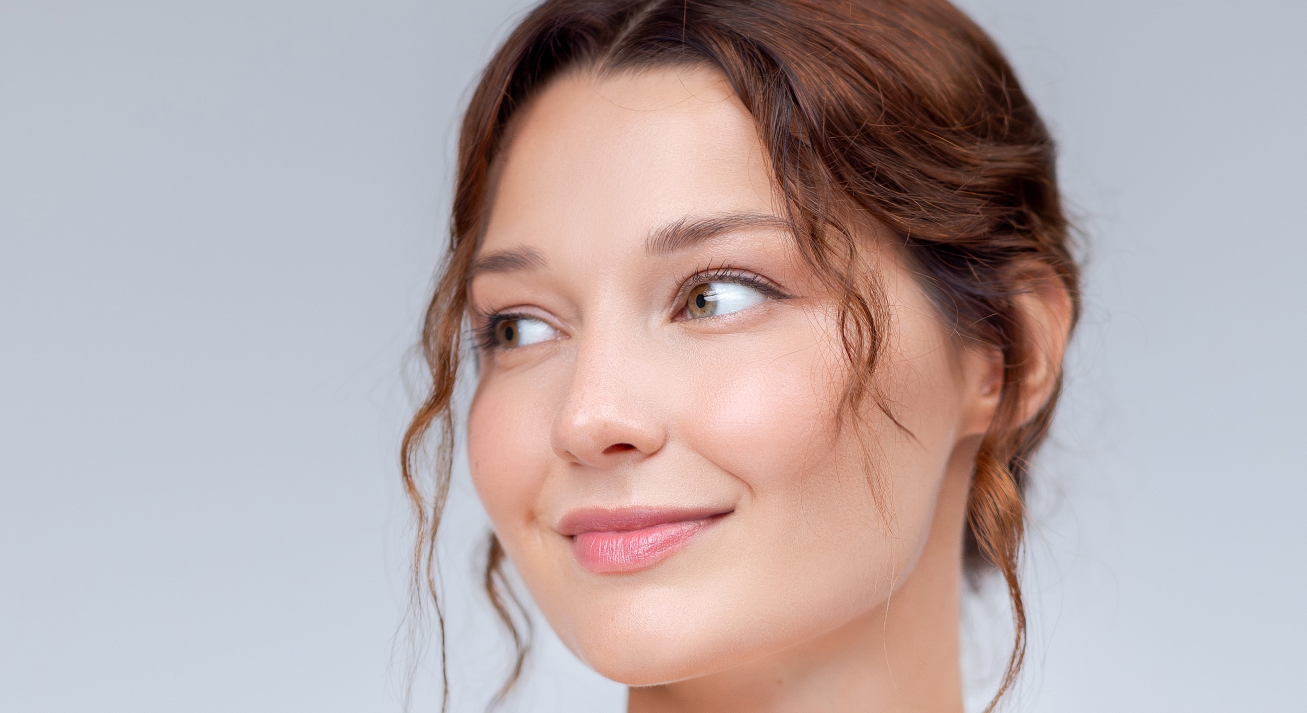 Smiling woman with wavy hair and soft makeup.